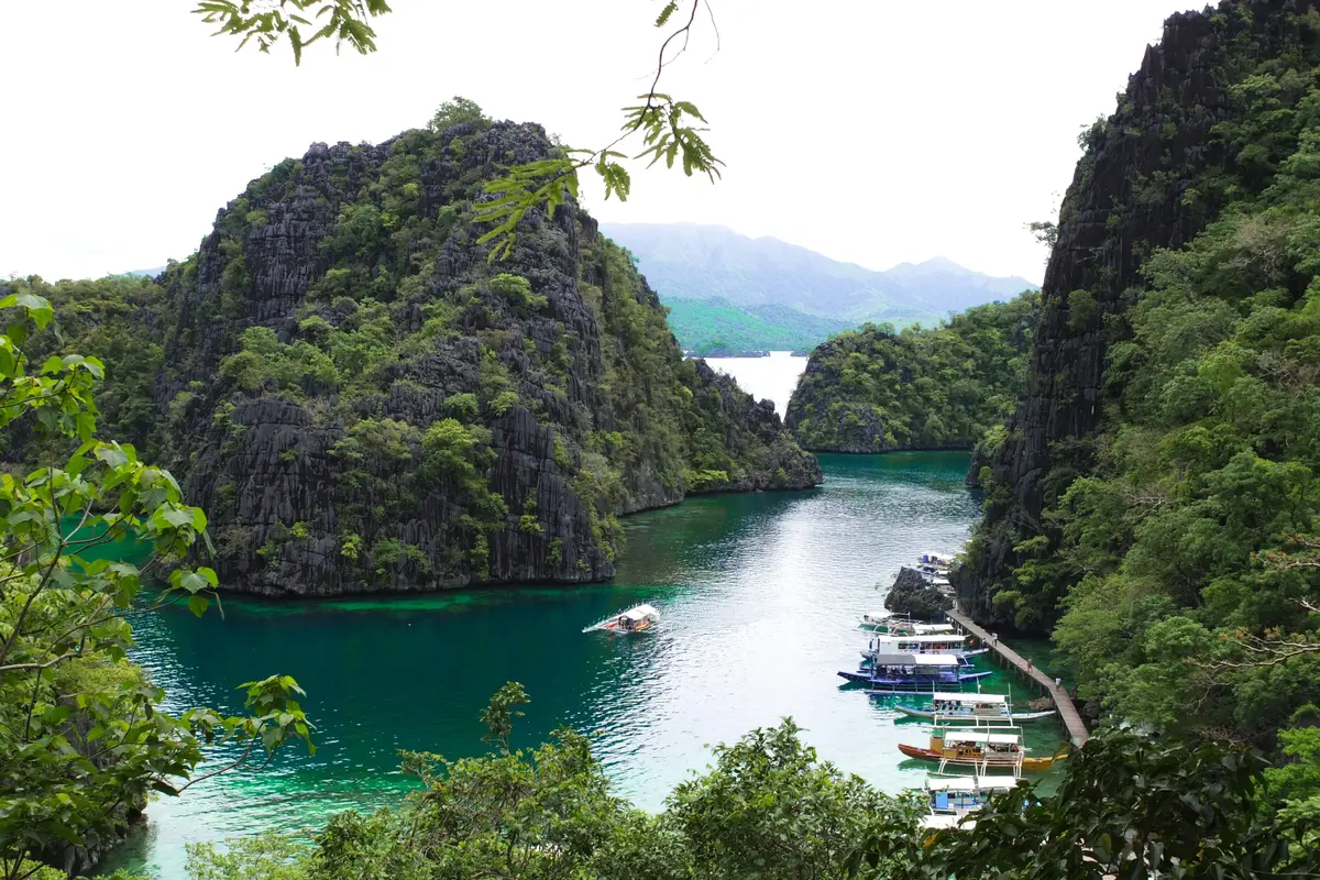 The view over Kayangan Lake's cove on Coron Island, with boats moored below limestone cliffs